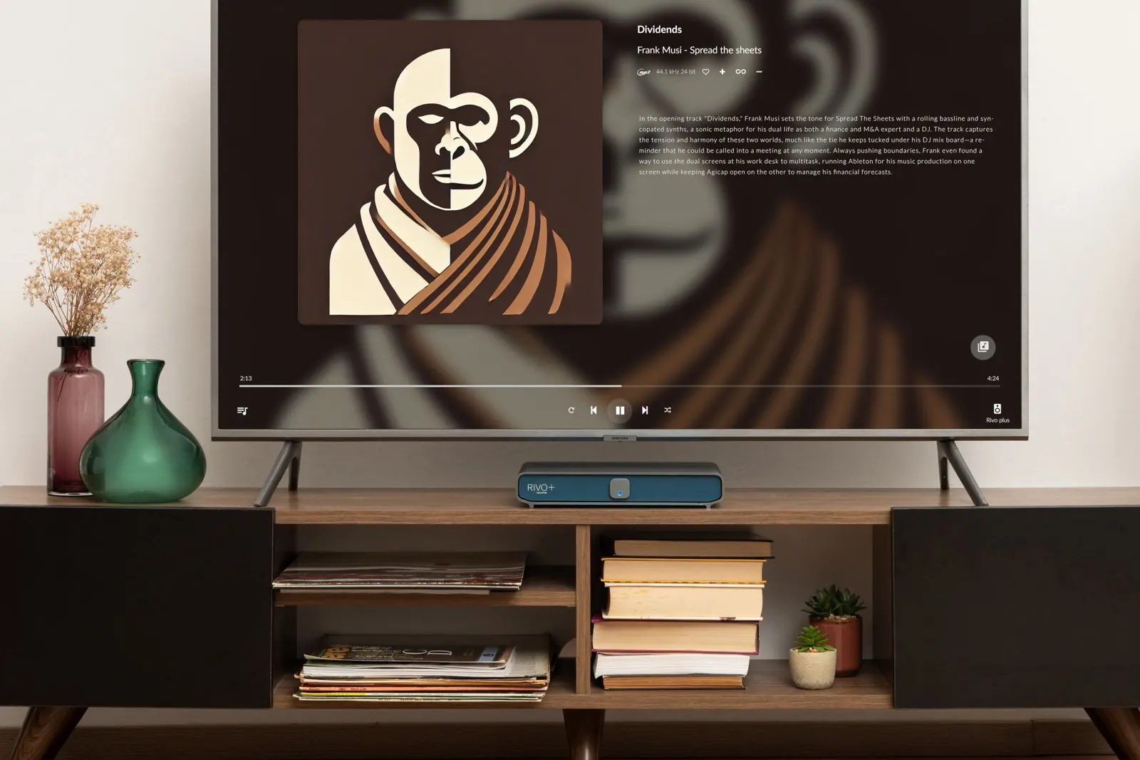 Ein Wohnzimmer mit einem Fernseher, der Albumcover und Titelinfos zeigt, über einem dunklen Holz-Sideboard mit Büchern, Schallplatten und Rivo Plus.