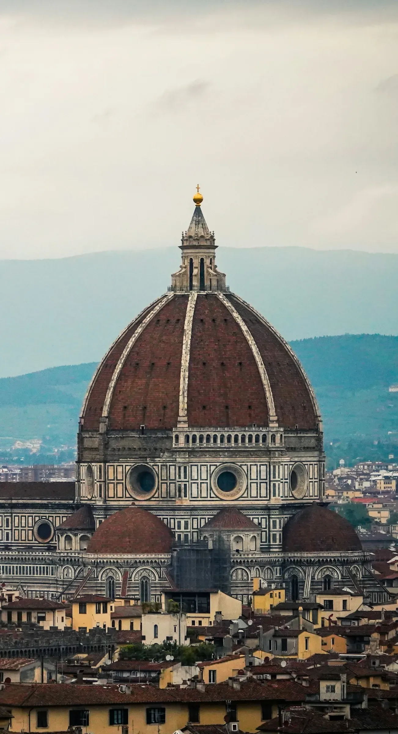 Florence seen from across the Arno, with the Duomo and Giotto's bell tower above the rooftops.